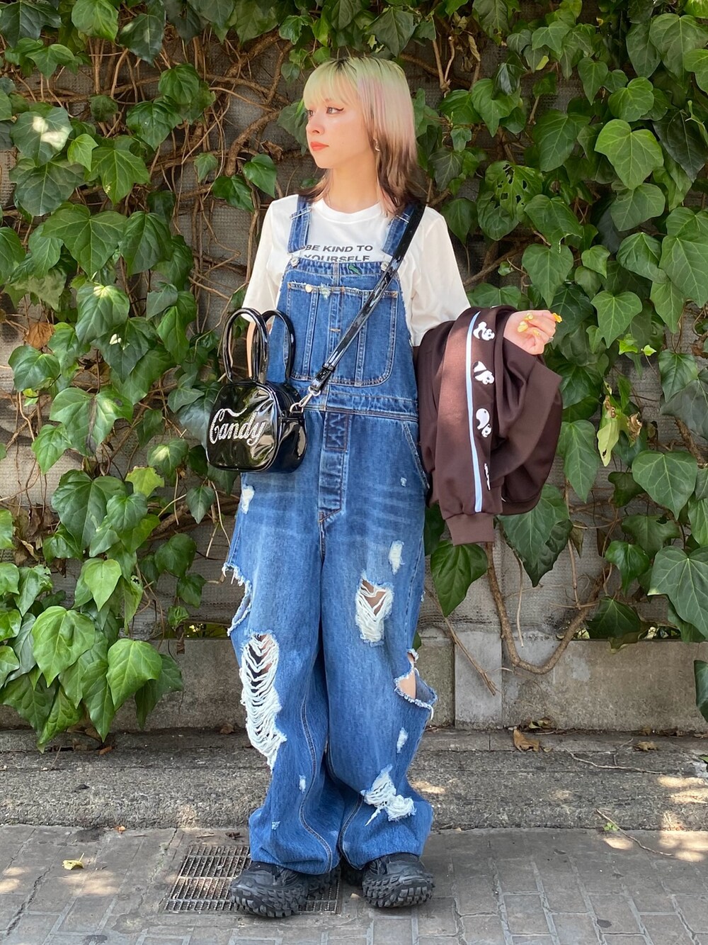 ブラック系のボストンバッグ、ブルー系のサロペット/オーバーオール、ホワイト系のTシャツ/カットソーを着用したレディースの夏コーディネートの5枚目の写真