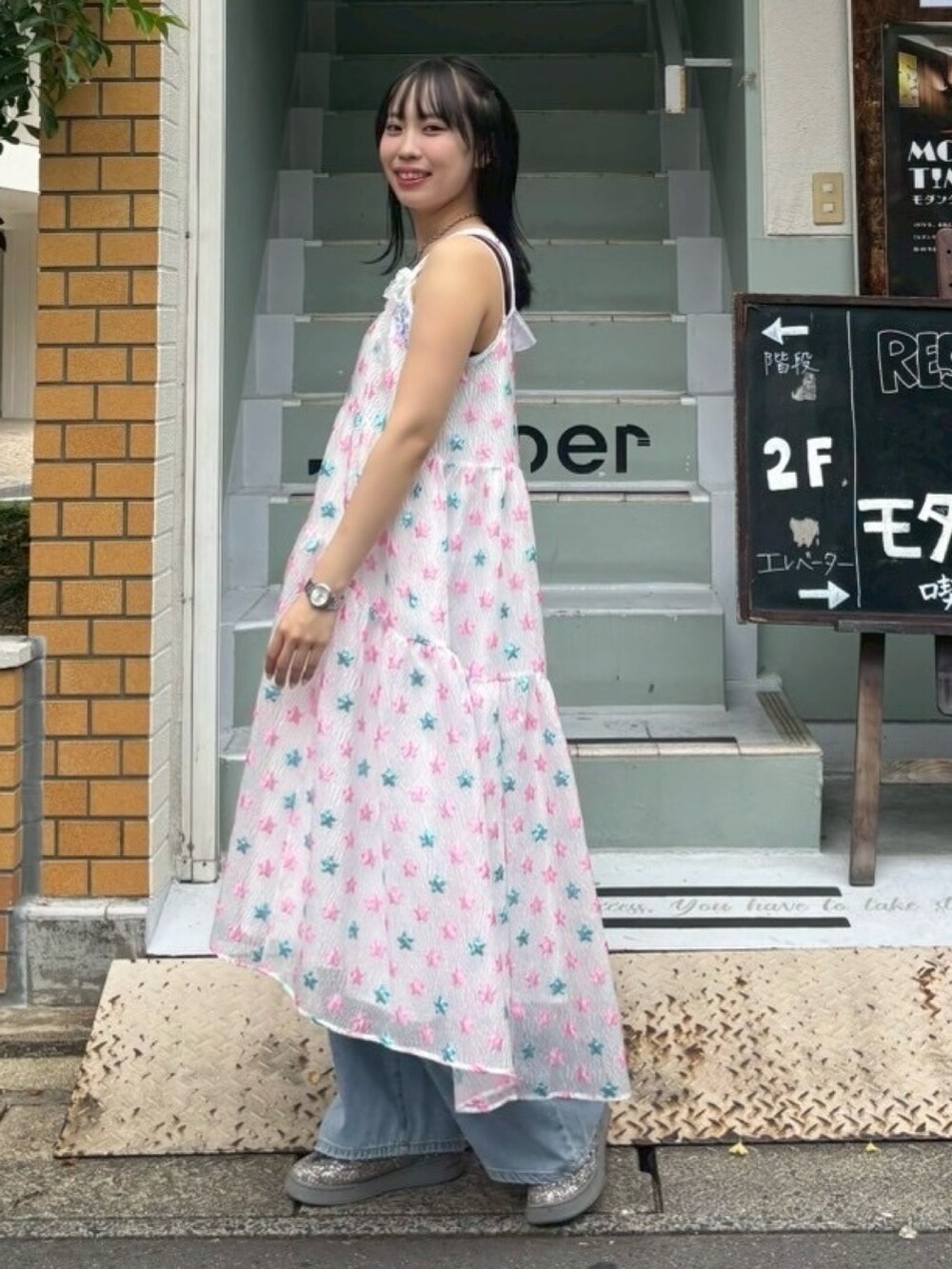 ピンク系のワンピース、ホワイト系のキャミソール、ブルー系のデニムパンツを着用したレディースの夏コーディネートの4枚目の写真