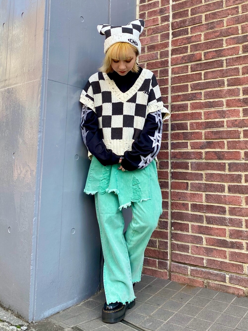 ブラック系のベスト、ブラック系のポロシャツ、グリーン系のその他パンツを着用したレディースの冬コーディネートの2枚目の写真