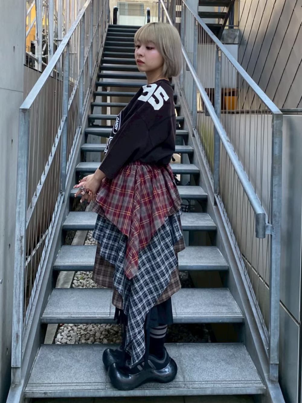 ブラック系のTシャツ/カットソー、レッド系のスカート、ブラック系のその他パンツを着用したレディースの春コーディネートの2枚目の写真