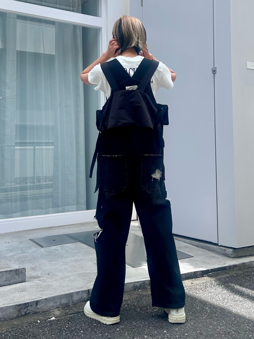 ホワイト系のTシャツ/カットソー、ブラック系のサロペット/オーバーオール、ブラック系のベストを着用したレディースの夏コーディネートの5枚目の写真