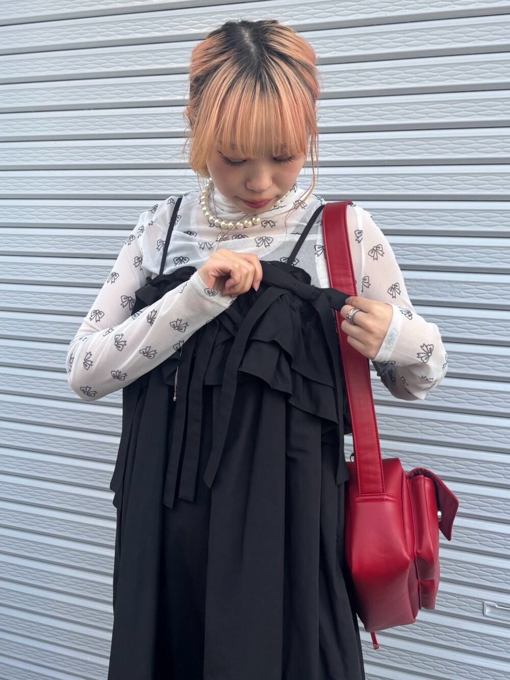 ブラック系のワンピース、ホワイト系のその他トップス、レッド系のショルダーバッグを着用したレディースの春コーディネートの4枚目の写真