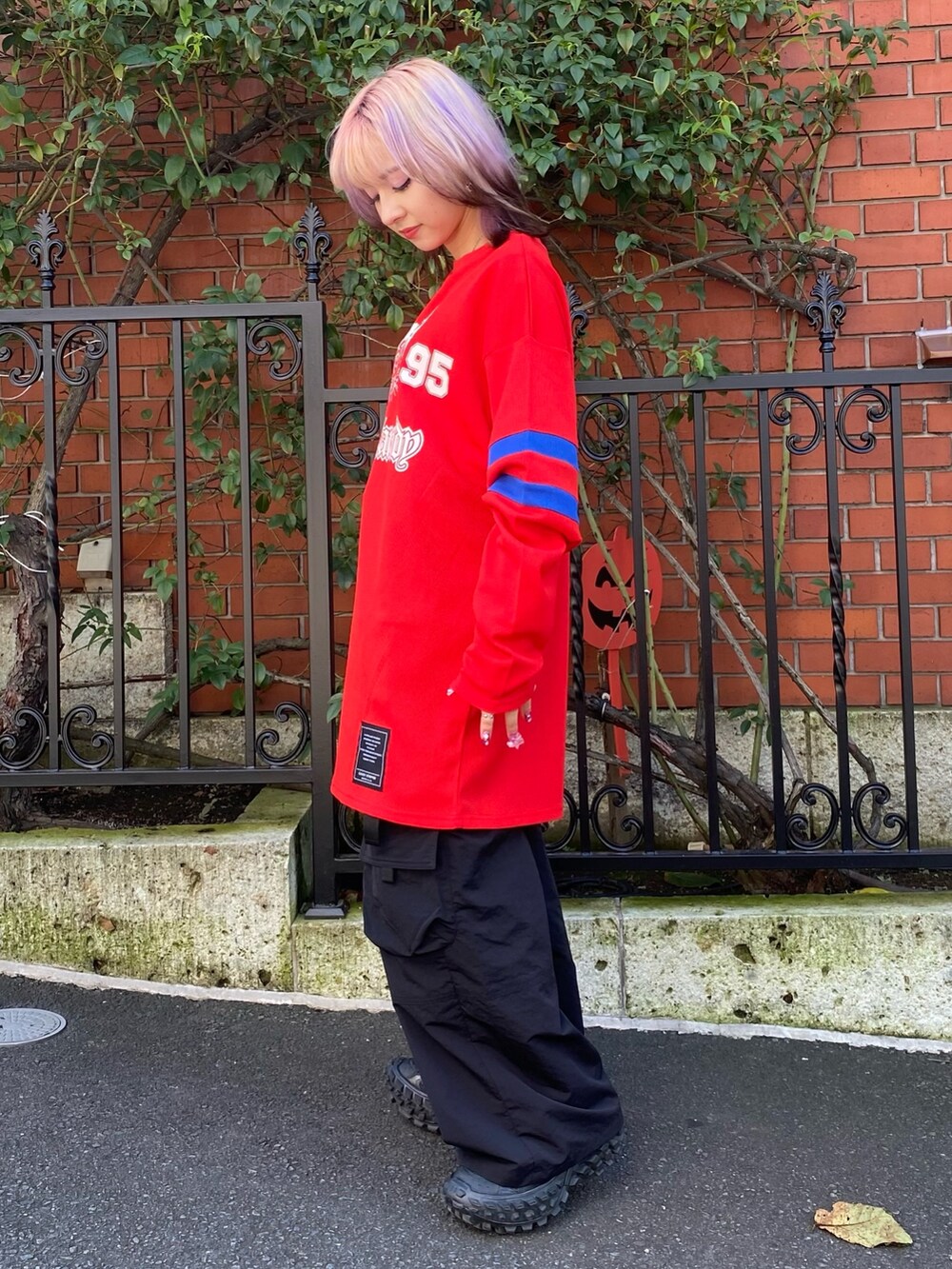 ブラック系のその他パンツ、レッド系のTシャツ/カットソーを着用したレディースの秋コーディネートの3枚目の写真