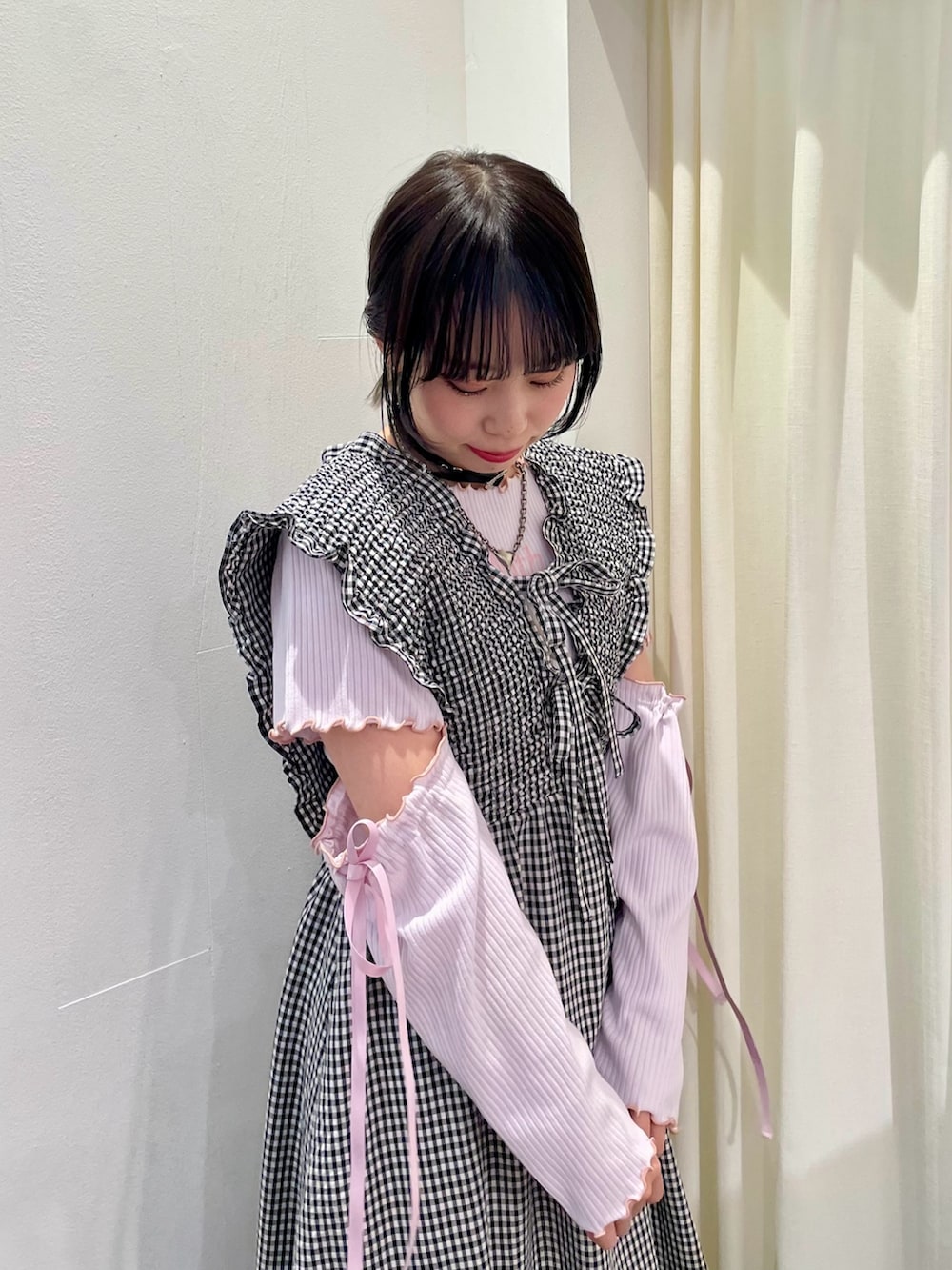 ピンク系のその他トップス、ホワイト系のジャンパースカート、ホワイト系のボディバッグ/ウエストポーチを着用したレディースの春コーディネートの5枚目の写真