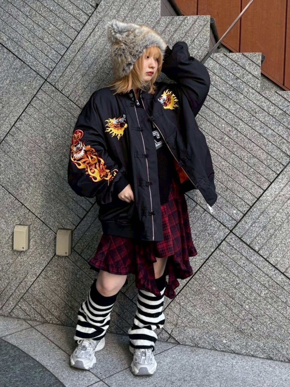 レッド系のワンピース、ブラック系のニット/セーター、ブラック系のMA-1を着用したレディースの秋コーディネートの4枚目の写真