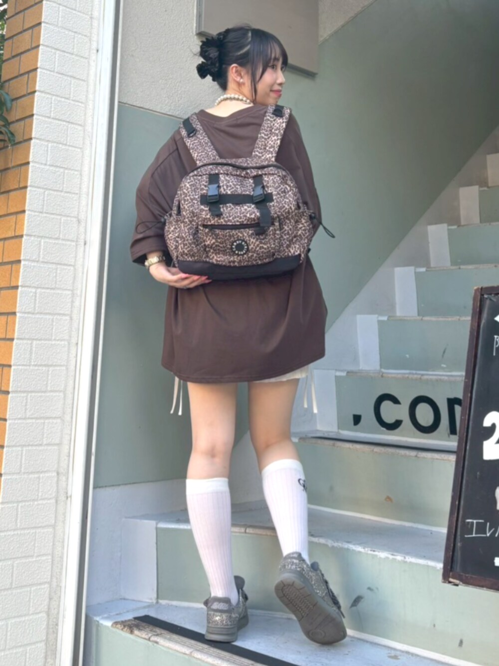 ホワイト系のその他パンツ、グリーン系のTシャツ/カットソー、その他のバックパック/リュックを着用したレディースの夏コーディネートの3枚目の写真