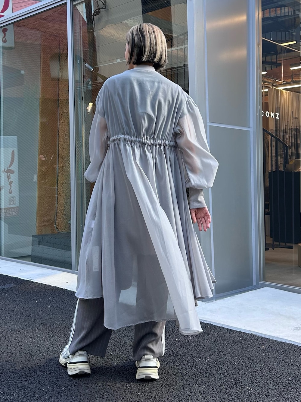 グレー系のドレス、ブラック系のTシャツ/カットソー、グレー系のその他パンツを着用したレディースの秋コーディネートの4枚目の写真