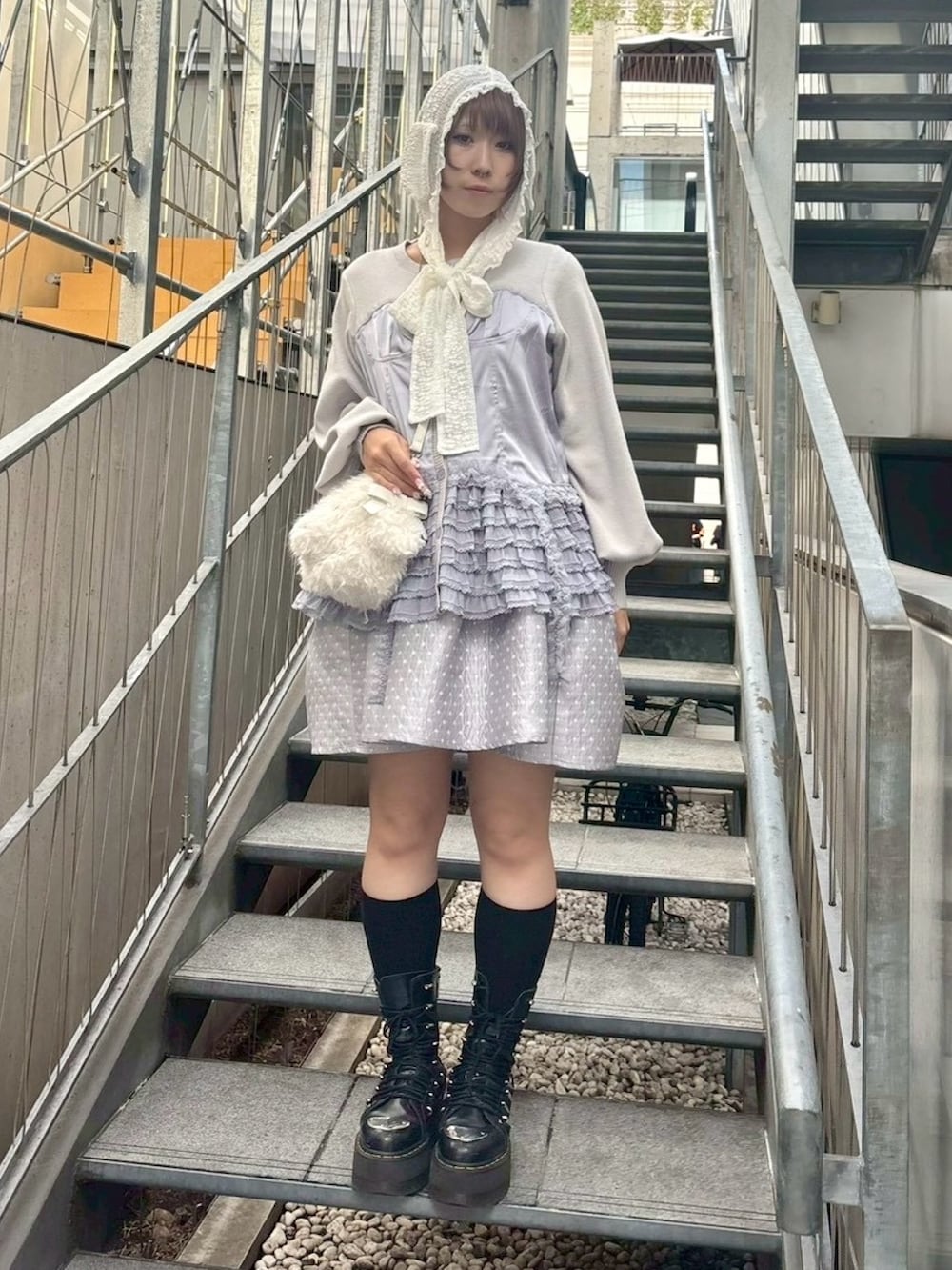 ホワイト系のショルダーバッグ、グレー系のワンピース、グレー系のカーディガン/ボレロを着用したレディースの秋コーディネートの2枚目の写真