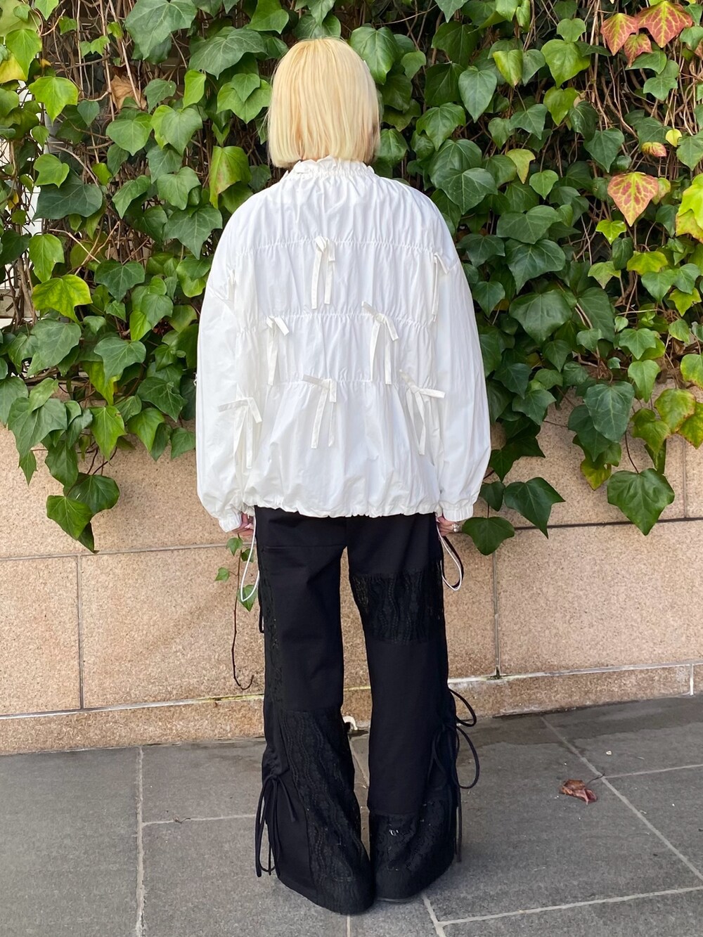 ホワイト系のブルゾン、グレー系のTシャツ/カットソー、ブラック系のその他パンツを着用したレディースの冬コーディネートの5枚目の写真