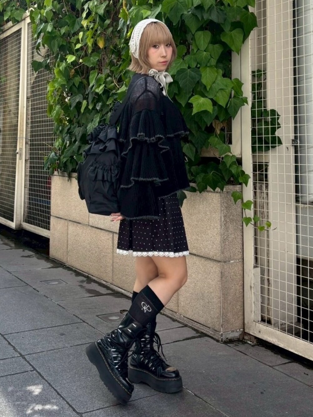 ブラック系のスカート、ブラック系のバックパック/リュック、ブラック系のカーディガン/ボレロを着用したレディースの秋コーディネートの3枚目の写真