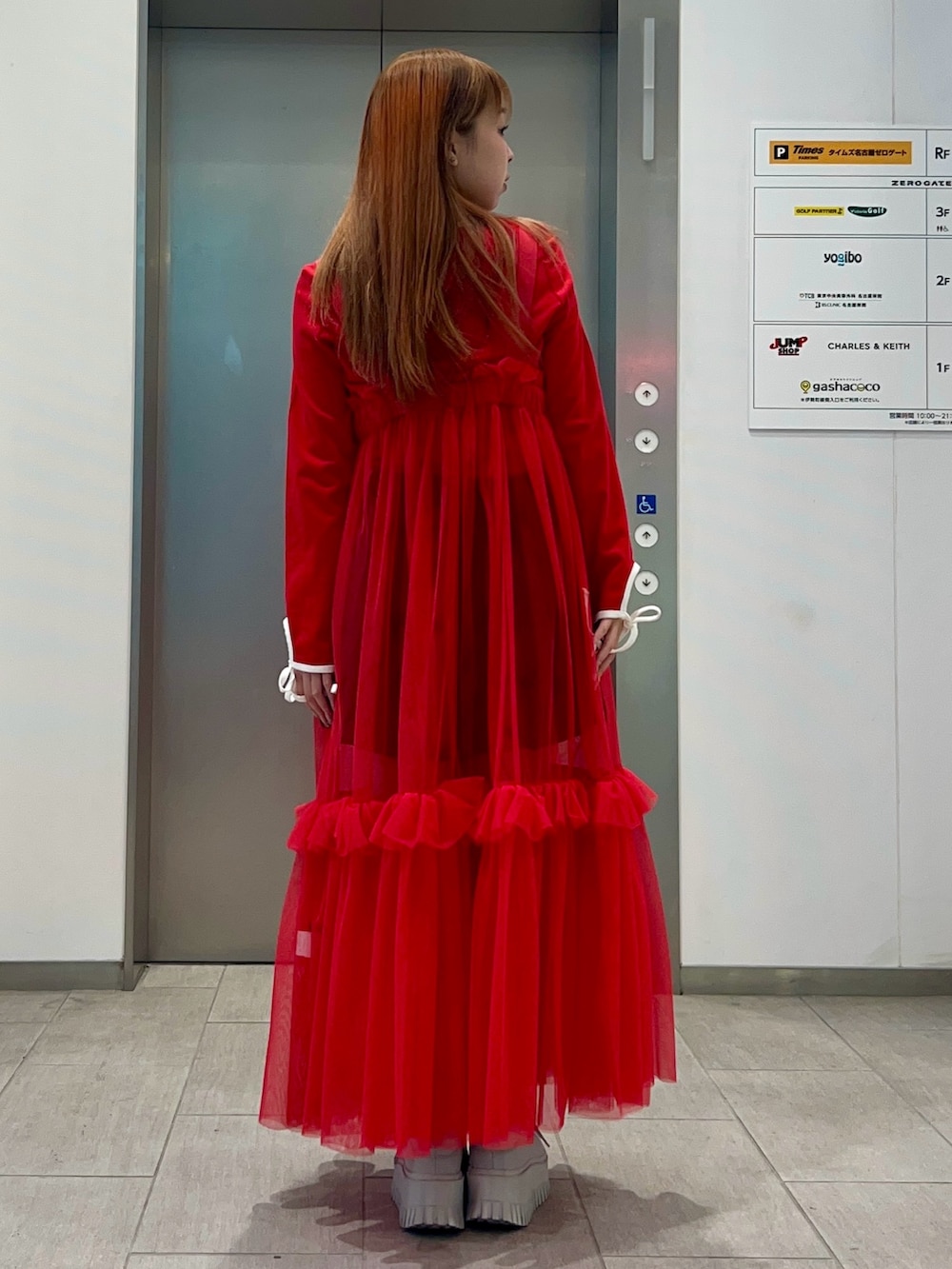 レッド系のスカート、ブラック系のその他パンツ、レッド系のTシャツ/カットソーを着用したレディースの冬コーディネートの4枚目の写真