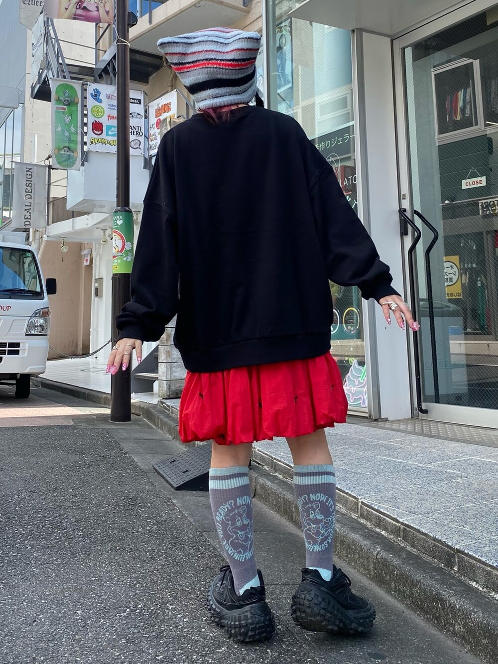 ブラック系のスウェット、レッド系のスカート、ブラック系のニットキャップ/ビーニーを着用したレディースの秋コーディネートの4枚目の写真