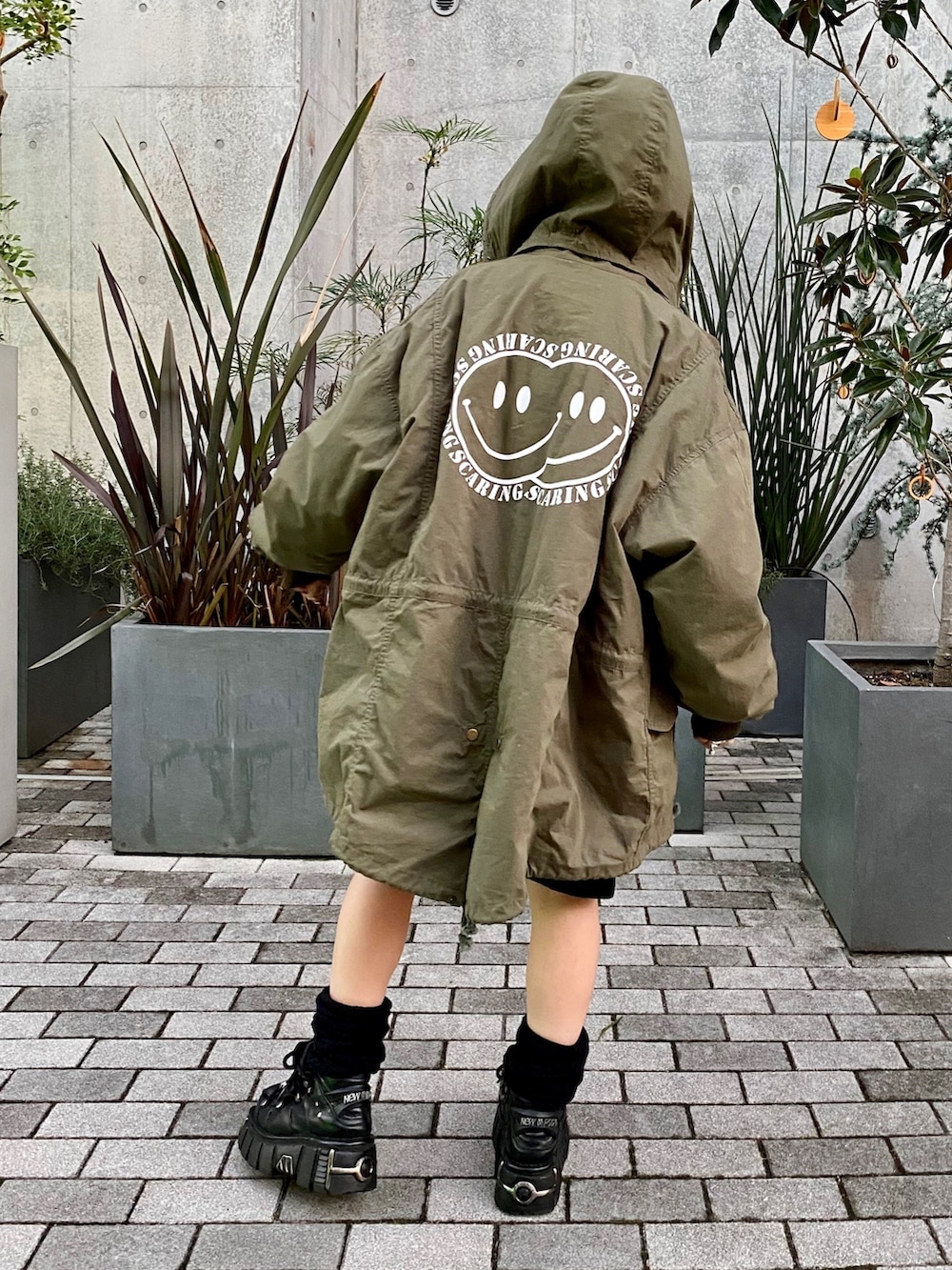 ブラック系のワンピース、グリーン系のモッズコートを着用したレディースの秋コーディネートの3枚目の写真