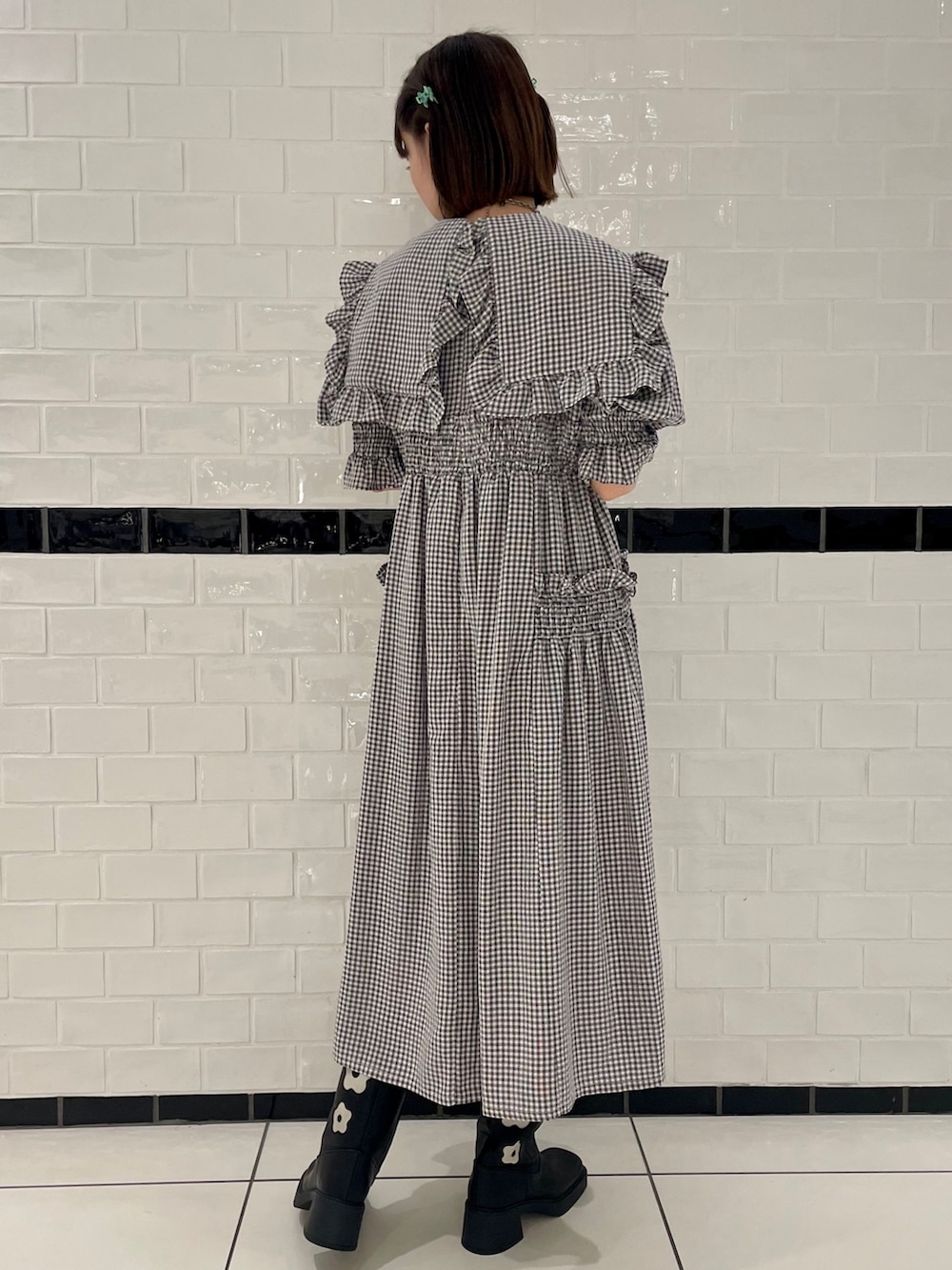 ホワイト系のワンピース、ブラック系のブーツを着用したレディースの春コーディネートの3枚目の写真