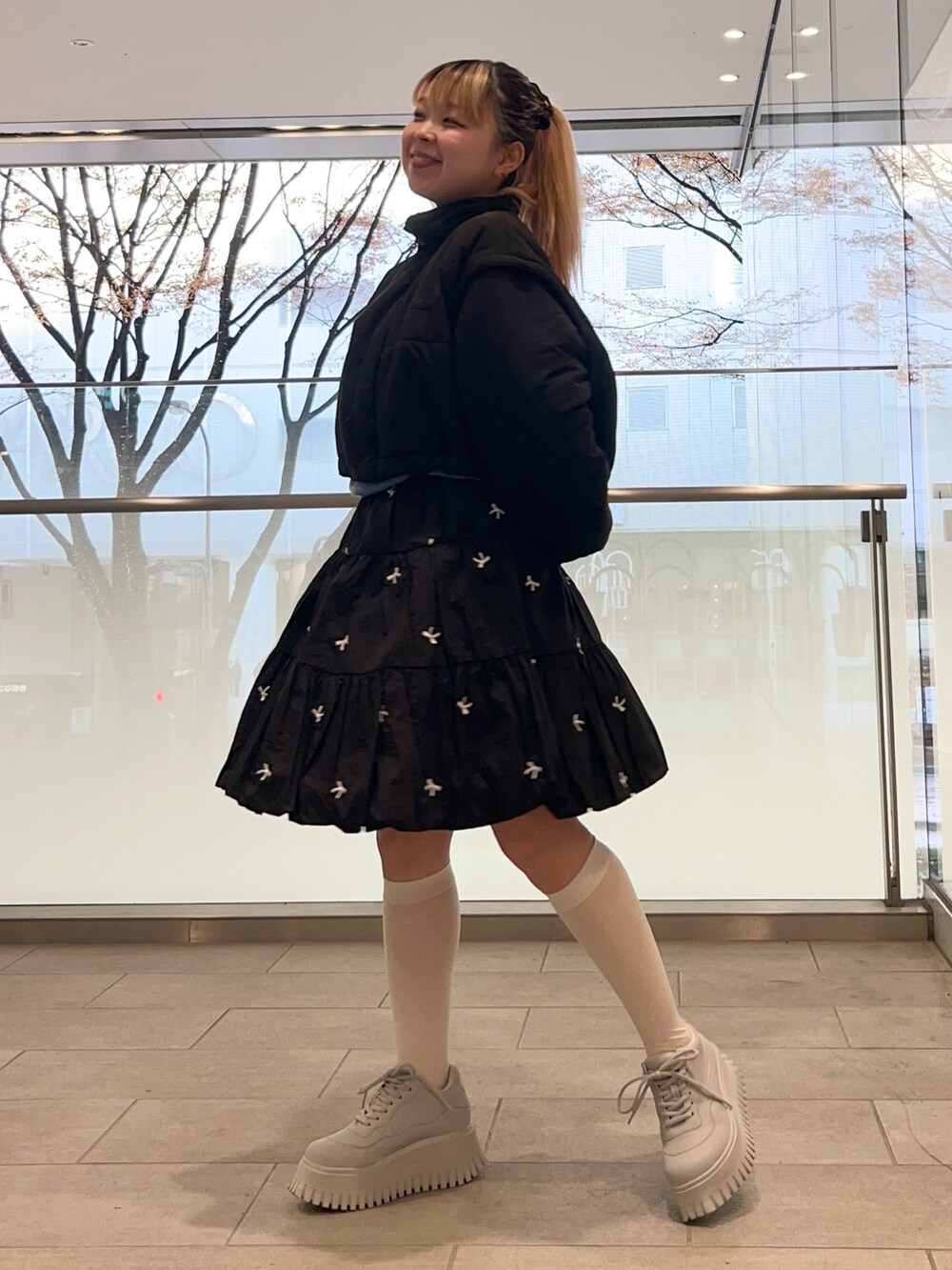 ブラック系のスカート、ブルー系のニット/セーター、ブラック系のダウンジャケット/コートを着用したレディースの冬コーディネートの3枚目の写真