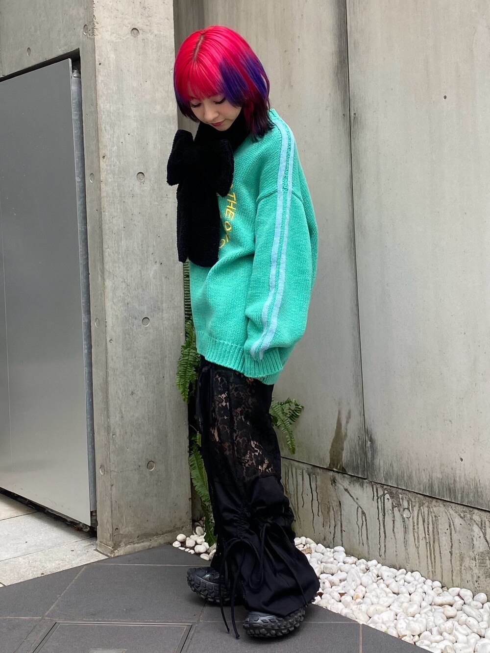 ブラック系のその他パンツ、グリーン系のニット/セーター、ブラック系のマフラーを着用したレディースの冬コーディネートの2枚目の写真