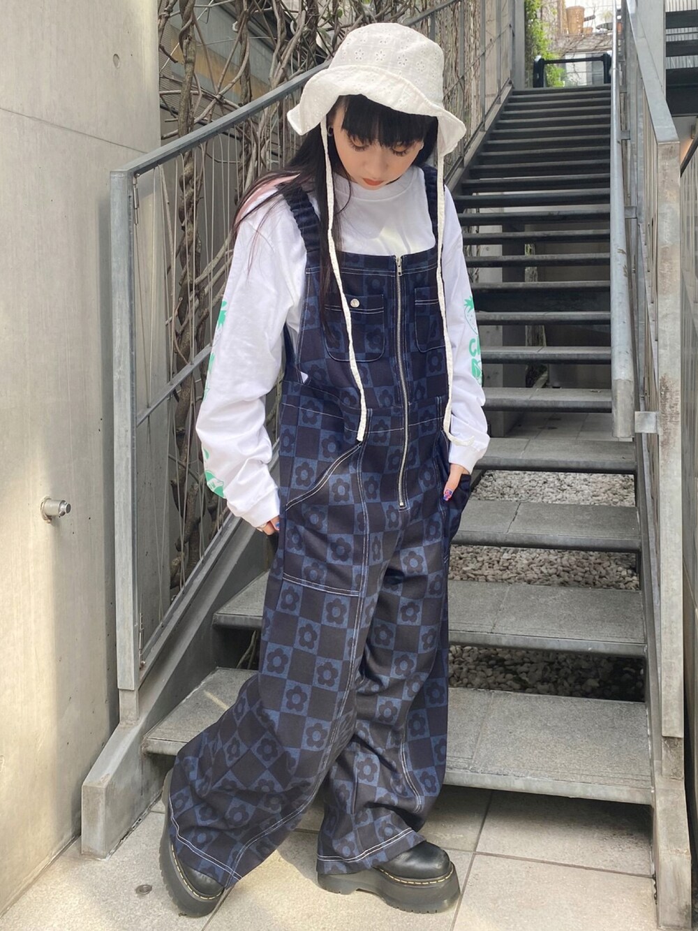 ホワイト系のTシャツ/カットソー、ブルー系のサロペット/オーバーオール、ホワイト系のハットを着用したレディースの春コーディネートの2枚目の写真