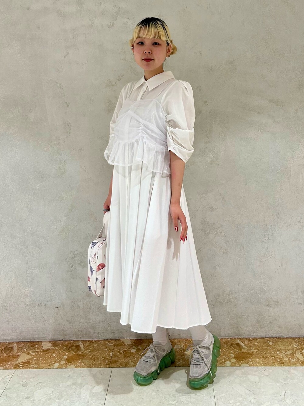 ホワイト系のハンドバッグ、ホワイト系のワンピースを着用したレディースの夏コーディネートの4枚目の写真