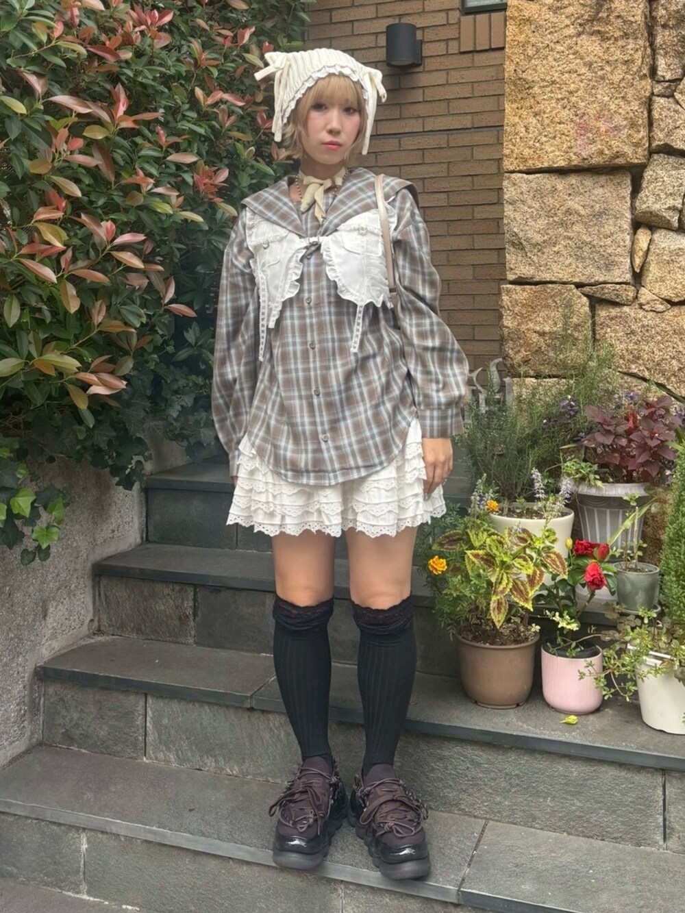 ブラウン系のシャツ/ブラウス、ホワイト系のベスト、ホワイト系のスカートを着用したレディースの秋コーディネートの4枚目の写真