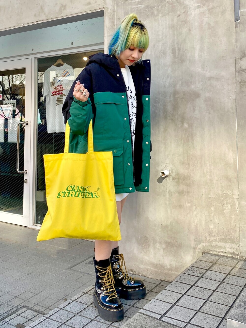 ブラック系のダウンジャケット/コート、ホワイト系のスウェット、イエロー系のトートバッグを着用したレディースの冬コーディネートの2枚目の写真