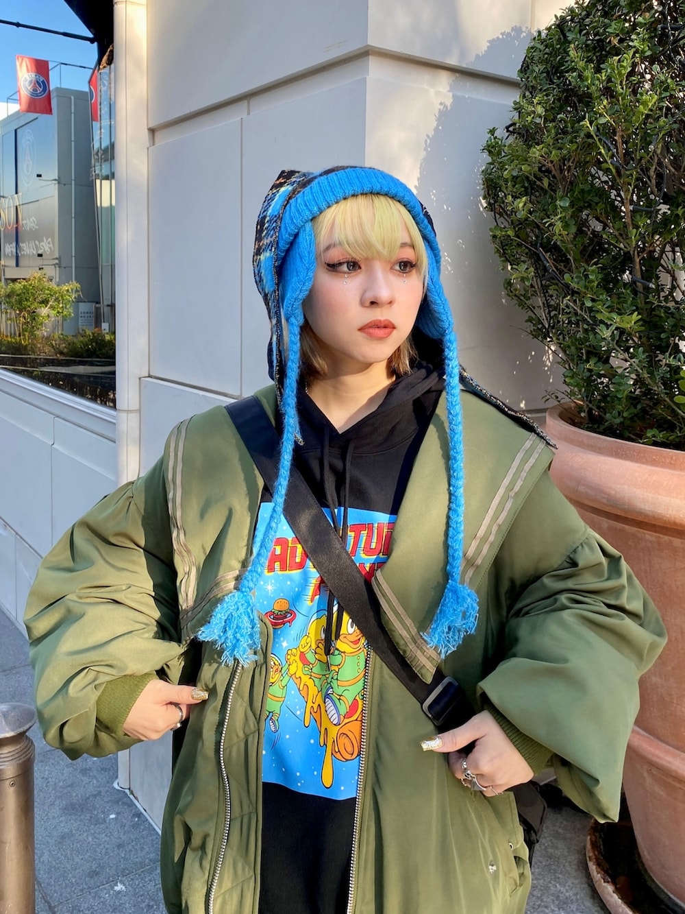 パープル系のスカート、グリーン系のMA-1、ブラック系のパーカーを着用したレディースの冬コーディネートの5枚目の写真