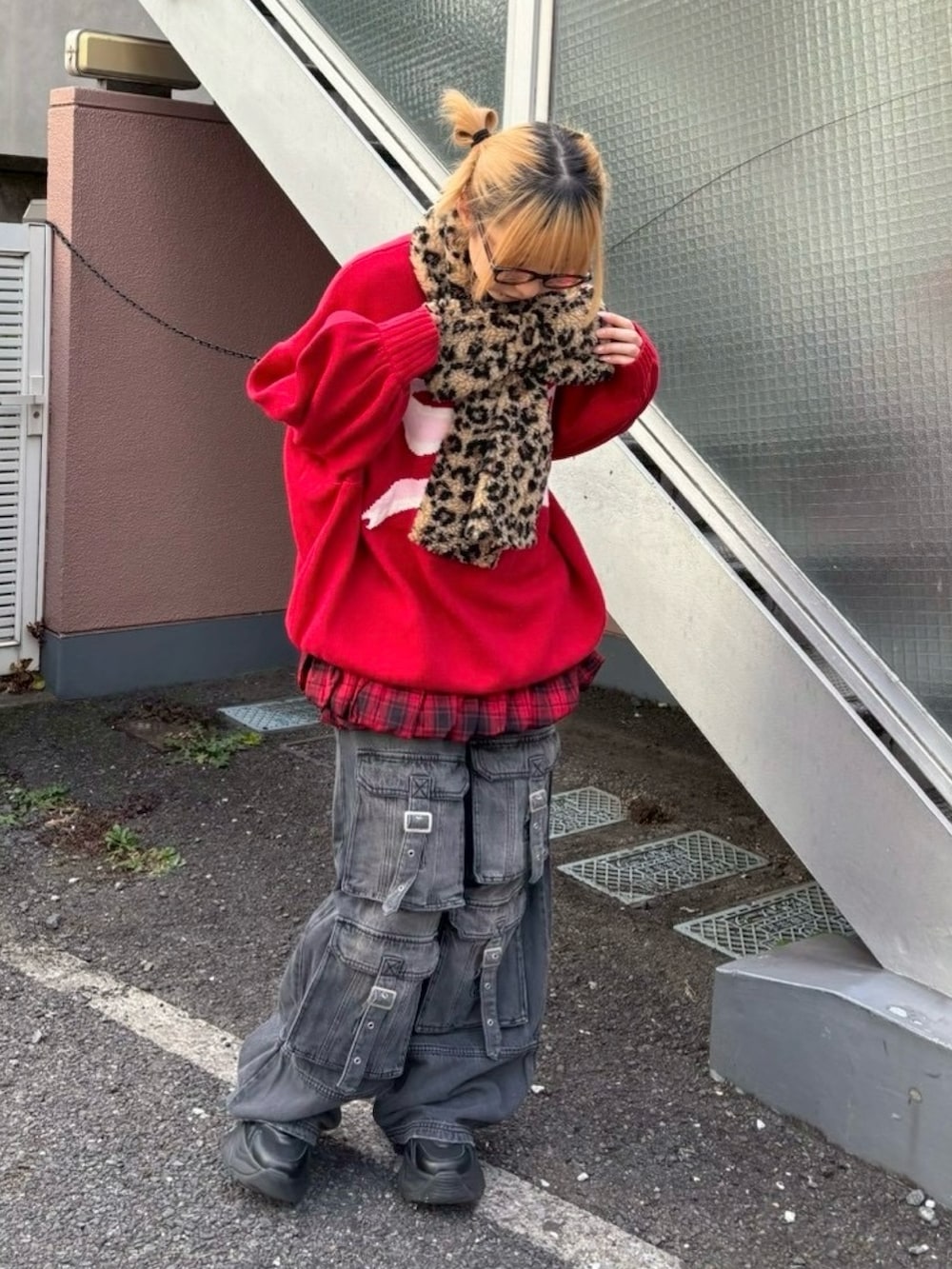 ブラック系のデニムパンツ、レッド系のスカート、レッド系のニット/セーターを着用したレディースの冬コーディネートの4枚目の写真