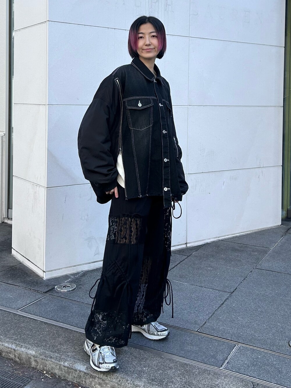 ブラック系のデニムジャケット、ホワイト系のニット/セーター、ブラック系のその他パンツを着用したレディースの冬コーディネートの4枚目の写真