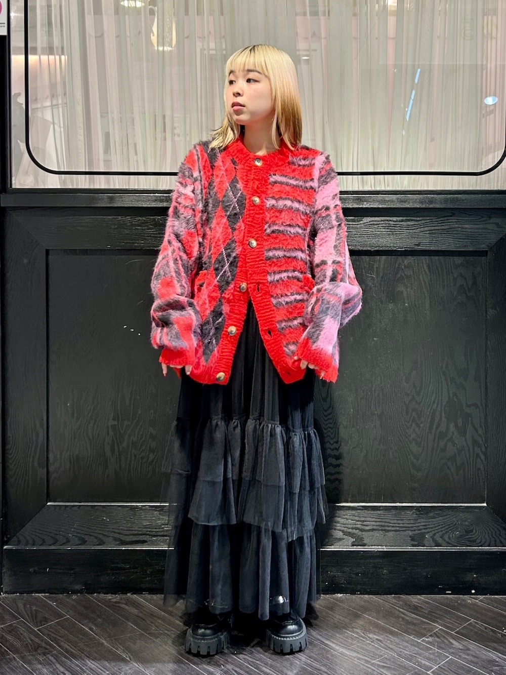 レッド系のカーディガン/ボレロ、ブラック系のワンピース、ブラック系のその他パンツを着用したレディースの冬コーディネートの2枚目の写真