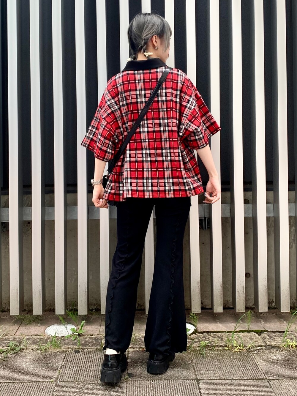 ブラック系のショルダーバッグ、レッド系のポロシャツ、ブラック系のその他パンツを着用したレディースの夏コーディネートの3枚目の写真