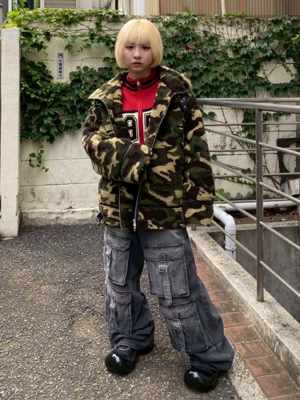 ブラック系のデニムパンツ、グリーン系のダウンジャケット/コート、レッド系のニット/セーターを着用したレディースの冬コーディネートの4枚目の写真