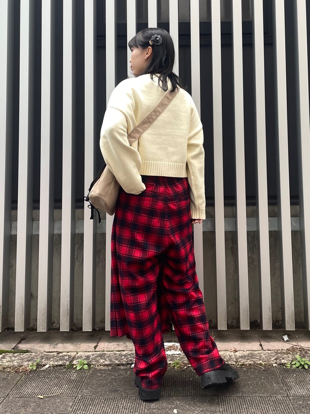 ベージュ系のショルダーバッグ、ホワイト系のニット/セーター、レッド系のその他パンツを着用したレディースの冬コーディネートの3枚目の写真