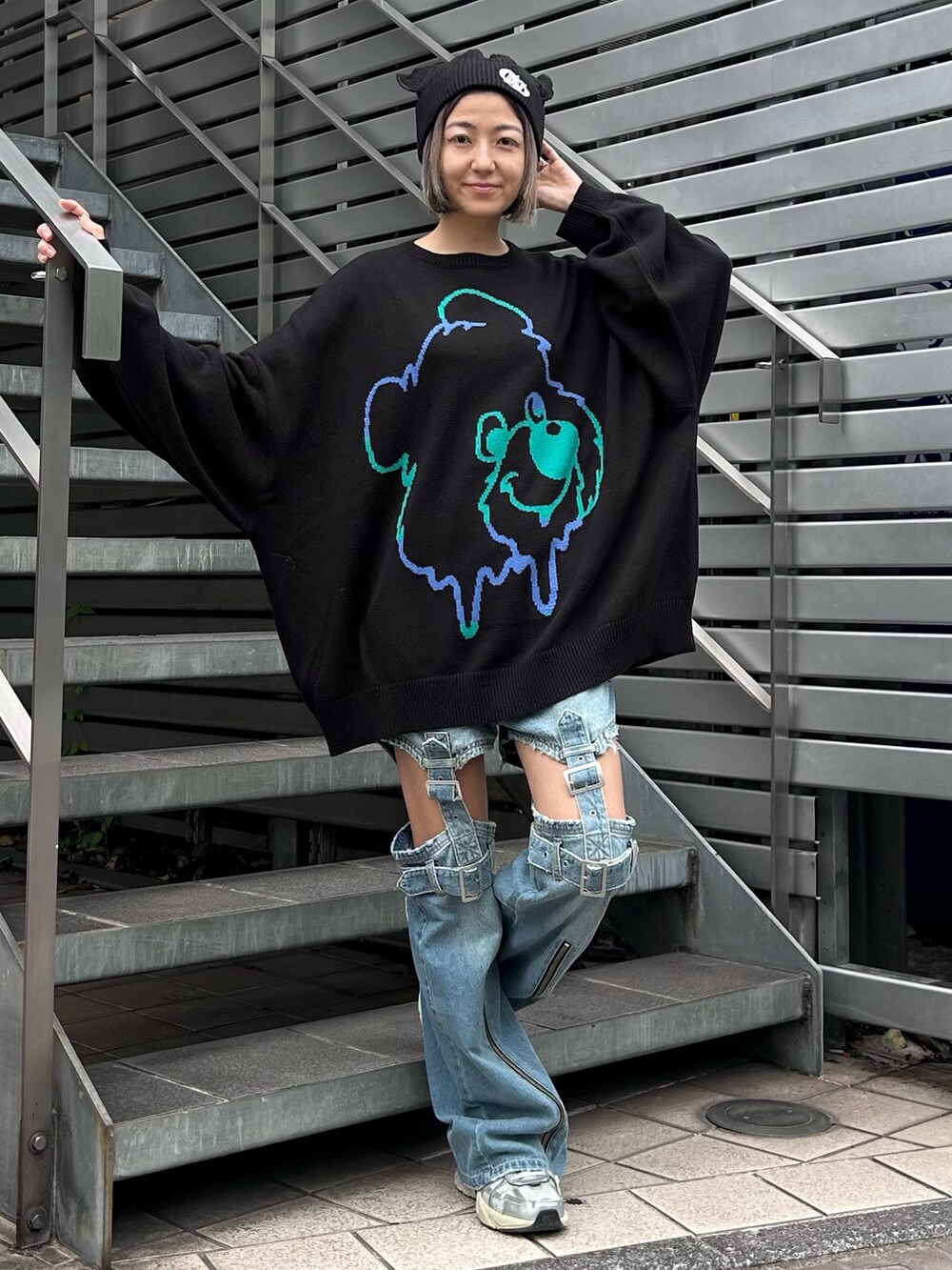 ブラック系のニット/セーター、ブルー系のデニムパンツ、シルバー系のシューズを着用したレディースの秋コーディネートの2枚目の写真