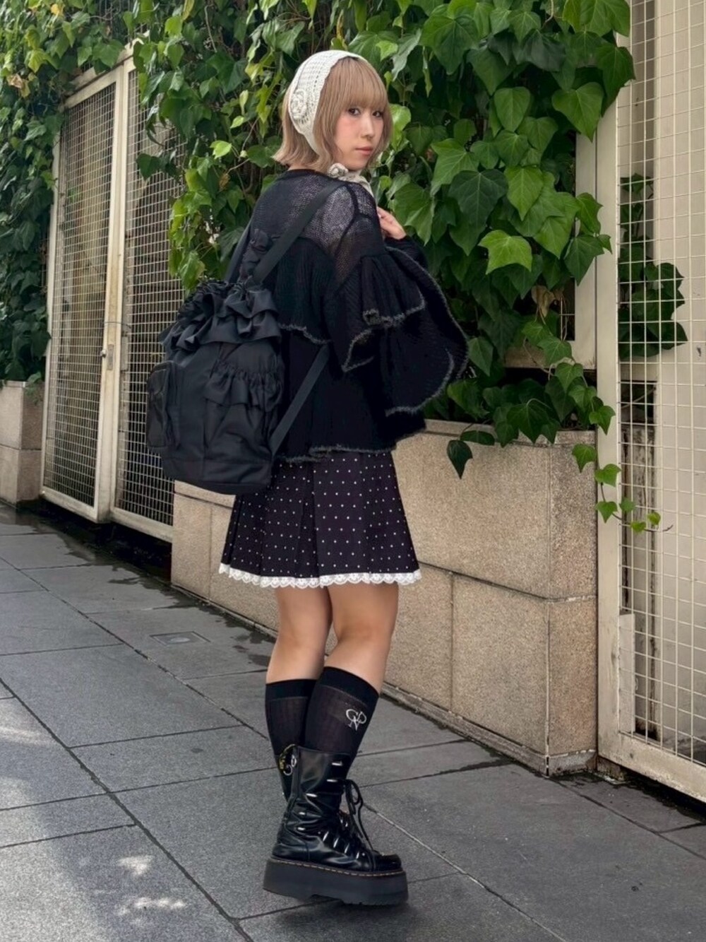 ブラック系のスカート、ブラック系のバックパック/リュック、ブラック系のカーディガン/ボレロを着用したレディースの秋コーディネートの5枚目の写真