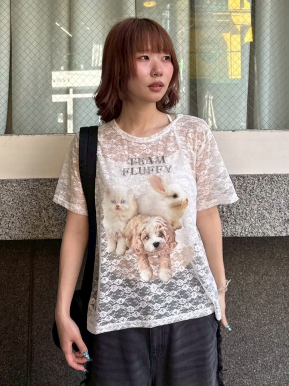 ブラック系のデニムパンツ、ブラック系のショルダーバッグ、ホワイト系のTシャツ/カットソーを着用したレディースの夏コーディネートの3枚目の写真