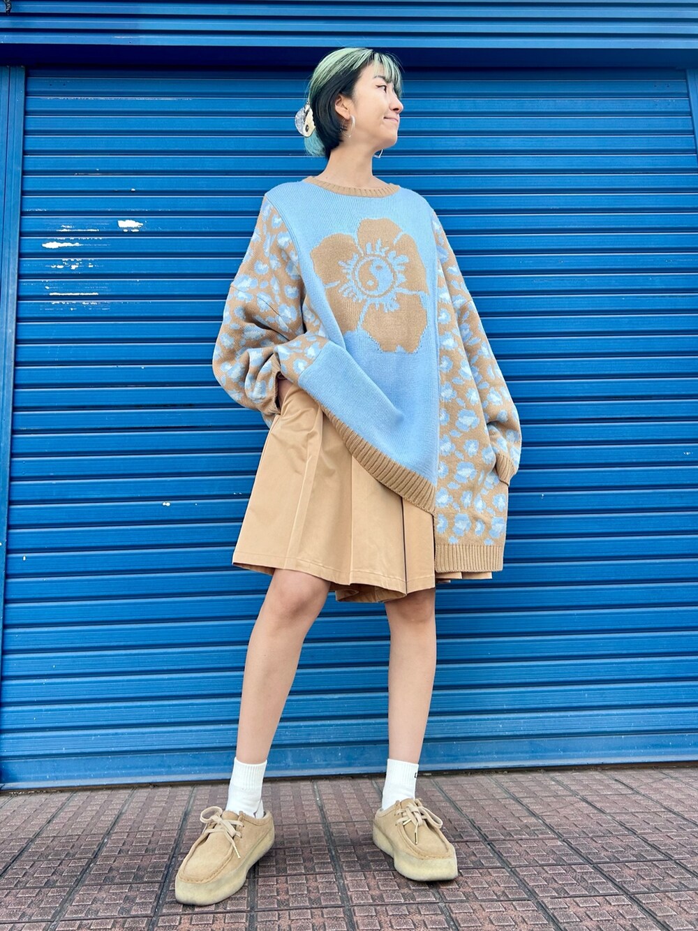 ベージュ系のスカート、ブルー系のニット/セーターを着用したレディースの冬コーディネートの2枚目の写真