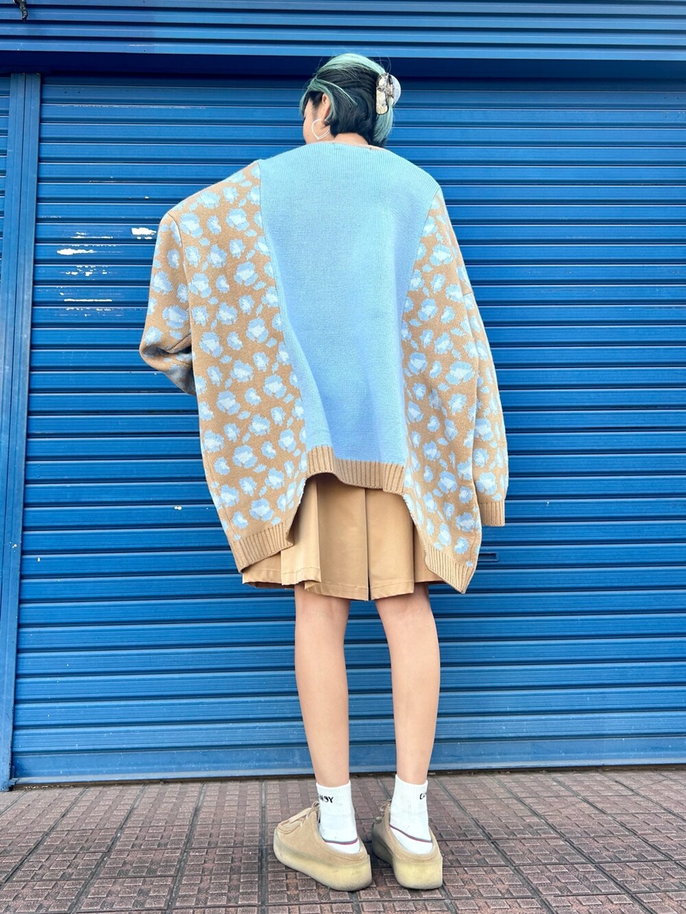 ベージュ系のスカート、ブルー系のニット/セーターを着用したレディースの冬コーディネートの4枚目の写真