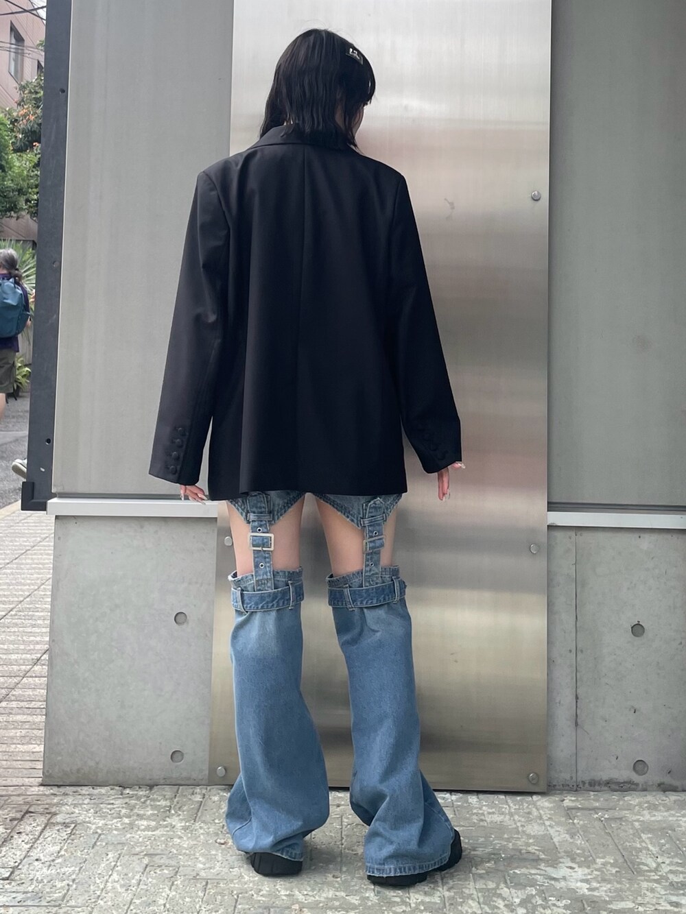 ブラック系のテーラードジャケット、ホワイト系のその他トップス、ブルー系のデニムパンツを着用したレディースの秋コーディネートの4枚目の写真