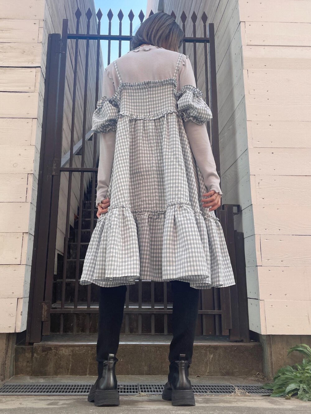 グレー系のワンピース、ブラック系のブーツを着用したレディースの冬コーディネートの4枚目の写真