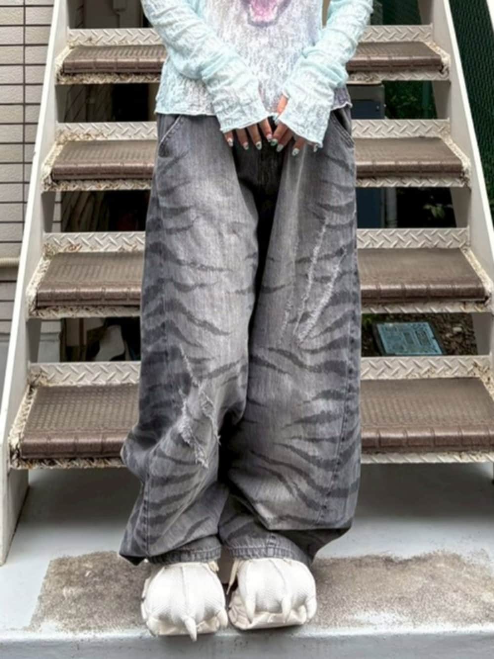ブラック系のデニムパンツ、ブルー系のTシャツ/カットソー、ホワイト系のスニーカーを着用したレディースの夏コーディネートの4枚目の写真