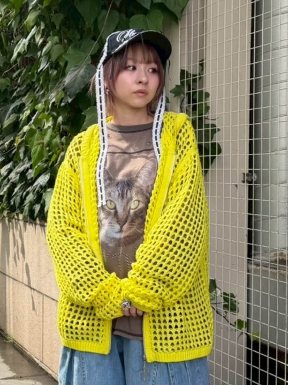 イエロー系のパーカー、ブラウン系のTシャツ/カットソー、ブルー系のデニムパンツを着用したレディースの春コーディネートの4枚目の写真