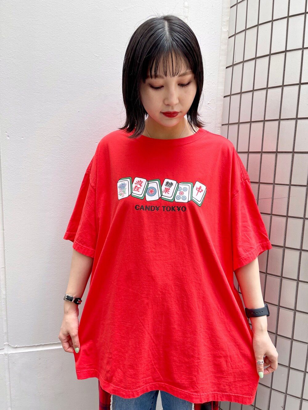 レッド系のTシャツ/カットソー、レッド系のデニムパンツ、ブラック系のスニーカーを着用したレディースの夏コーディネートの3枚目の写真