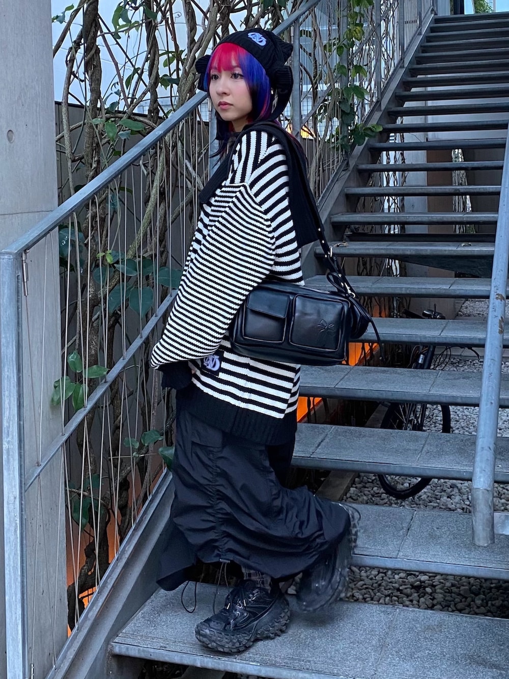 ブラック系のスカート、ブラック系のショルダーバッグ、ブラック系のニット/セーターを着用したレディースの冬コーディネートの3枚目の写真