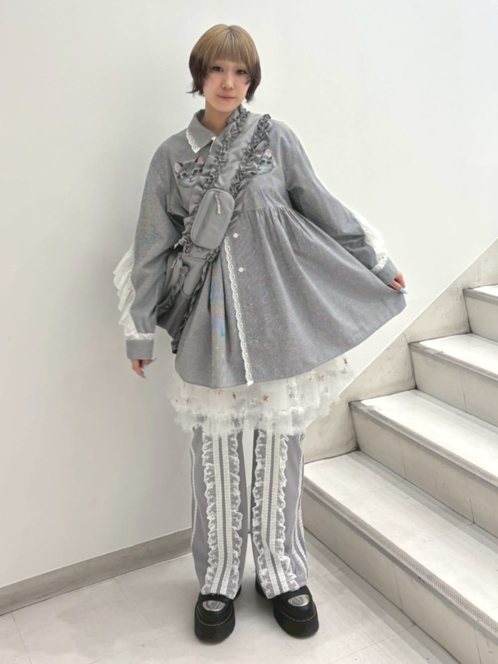 グレー系のその他パンツ、ホワイト系のスカート、グレー系のショルダーバッグを着用したレディースの春コーディネートの2枚目の写真