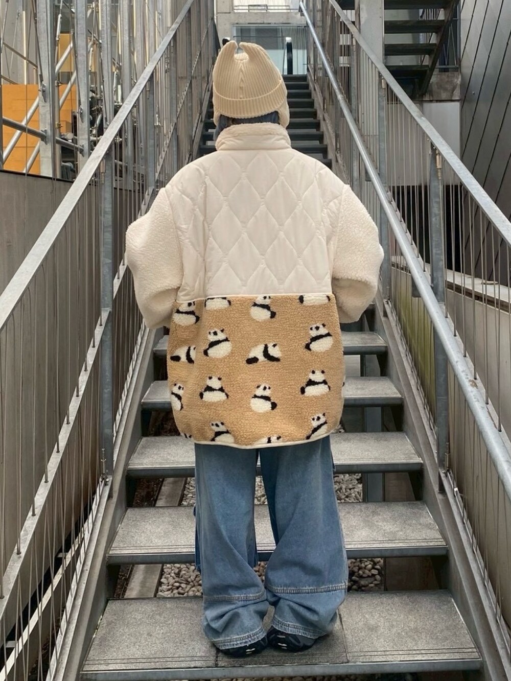 ホワイト系のダウンジャケット/コート、ブルー系のデニムパンツ、ホワイト系のニットキャップ/ビーニーを着用したレディースの秋コーディネートの3枚目の写真