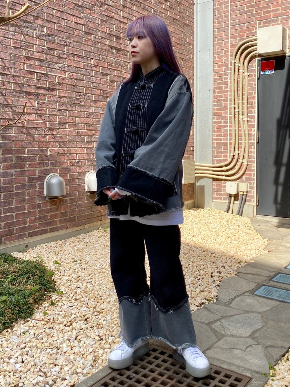 ブラック系のデニムパンツ、ブラック系のデニムジャケット、ホワイト系のTシャツ/カットソーを着用したレディースの春コーディネートの4枚目の写真