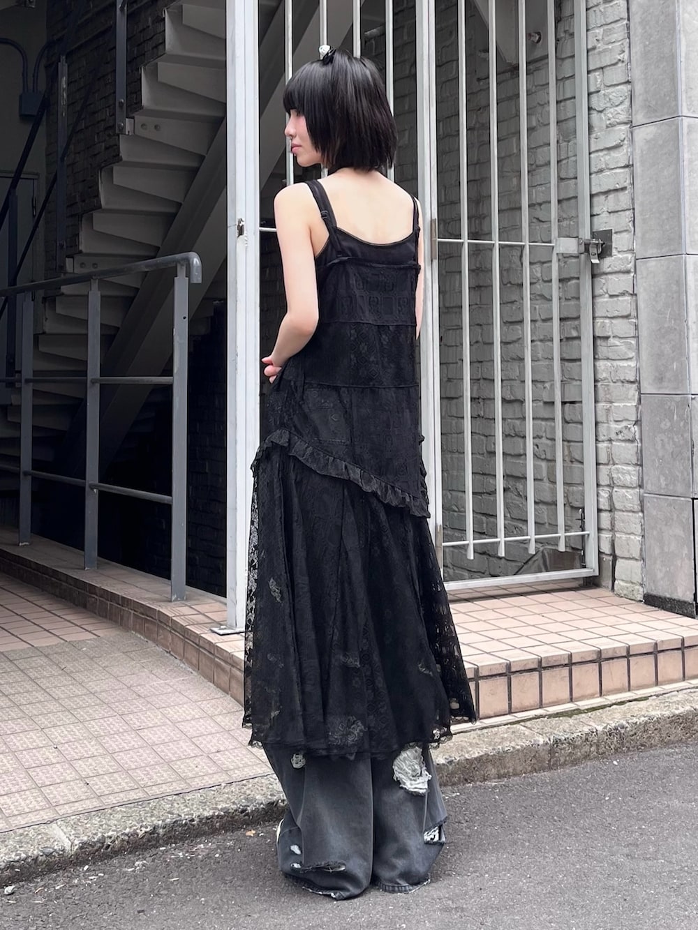 ブラック系のデニムパンツ、ブラック系のキャミソール、ブラック系のワンピースを着用したレディースの夏コーディネートの2枚目の写真