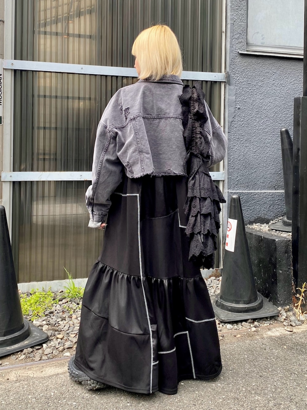 ブラック系のデニムジャケット、グレー系のその他トップス、ブラック系のワンピースを着用したレディースの春コーディネートの4枚目の写真