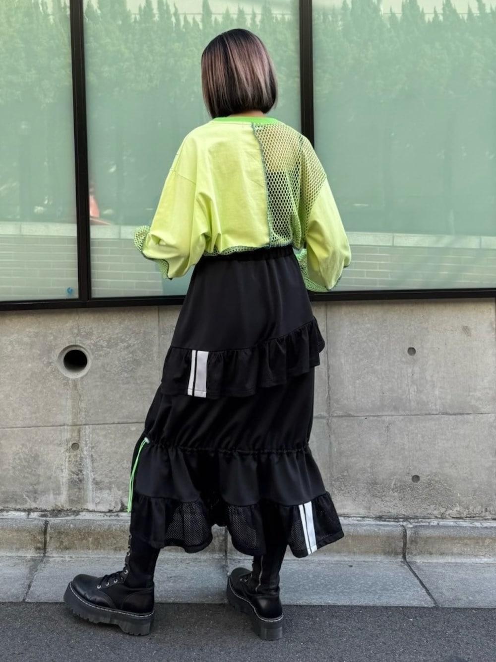 グリーン系のTシャツ/カットソー、ブラック系のスカートを着用したレディースの春コーディネートの5枚目の写真