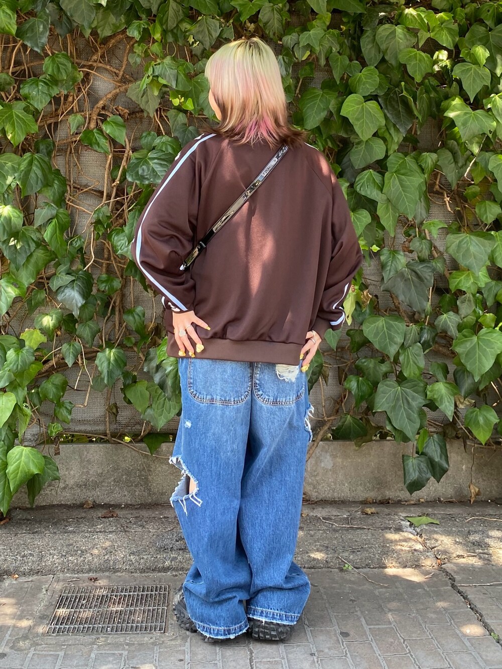 ブラック系のボストンバッグ、ブルー系のサロペット/オーバーオール、ホワイト系のTシャツ/カットソーを着用したレディースの夏コーディネートの3枚目の写真