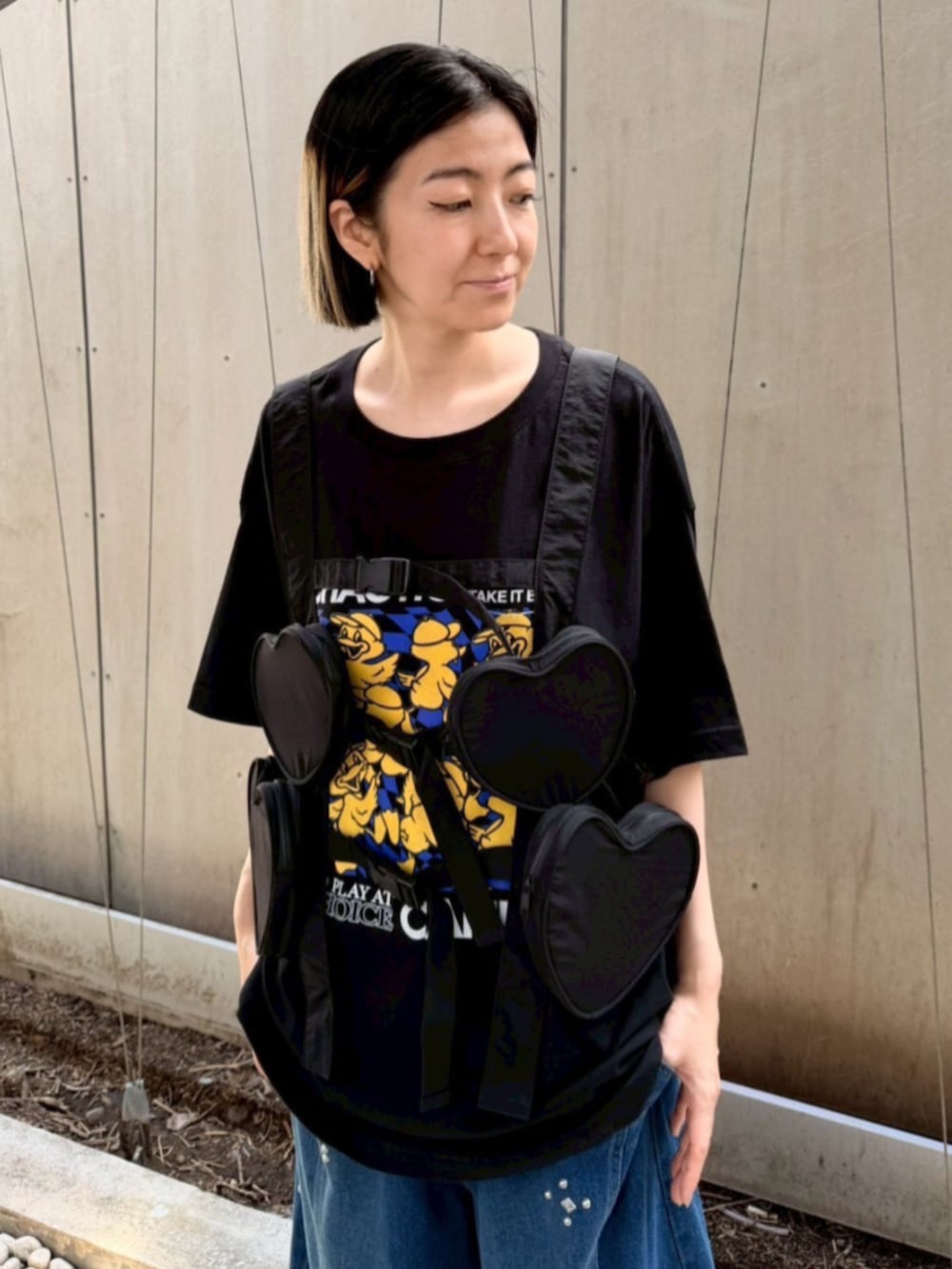 ブルー系のデニムパンツ、ブラック系のボディバッグ/ウエストポーチ、ブラック系のTシャツ/カットソーを着用したレディースの夏コーディネートの4枚目の写真